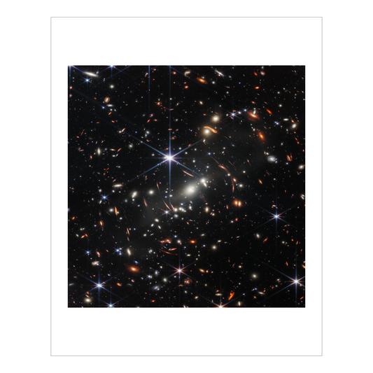 A black background, thousands of galaxies spread across the view, varying in colors and shapes. Some are warped by gravity into odd shapes. Bright stars have large diffraction spikes